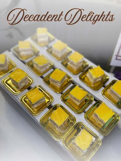 Our 'Decadent Delights' include a variety of Indian sweets, like this layered barfi. Each piece is crafted to be a small bite of heaven.