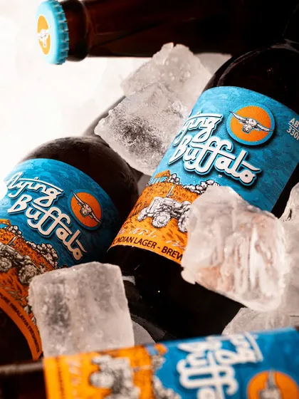 A group shot of Flying Buffalo beer bottles nestled in ice. This style of shot for a product catalogue conveys a sense of being ice-cold and ready for a party.