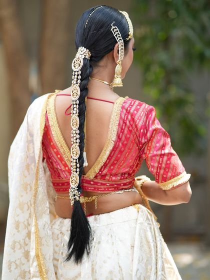 A full view of the back, highlighting the stunning hairstyle with a long braid accessory and the low-back blouse.