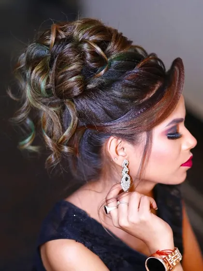 A messy, textured updo with hints of color, perfect for a modern reception look. This style is both chic and effortless, pairing well with contemporary outfits.