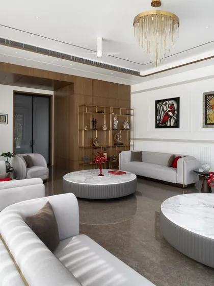 A view of the living room highlighting the curated art and a bespoke brass shelving unit. We work closely with clients to integrate their personal collections, making each space a true reflection of their identity.