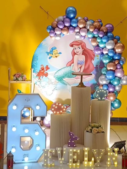 An enchanting Little Mermaid themed birthday party for an 8th birthday, with an Ariel backdrop and under-the-sea props.