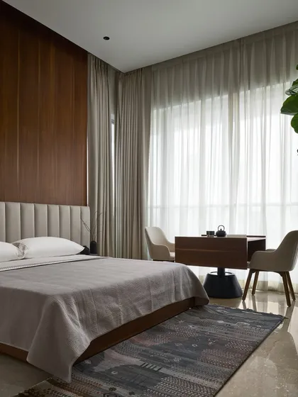 A wide view of the master bedroom, showcasing how the custom-designed dynamic study and music table fits into the overall scheme of quiet luxury. The piece is designed to be a hero without overwhelming the room's tranquil ambiance.
