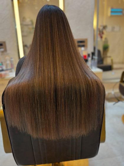 The sleekness and shine of this caramel brown hair are a testament to our quality products and expert application.