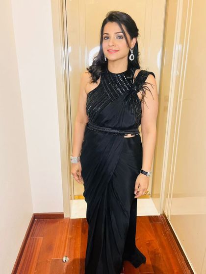 This custom black drape saree is the definition of effortless elegance. The hand-embroidered blouse features feather details on the shoulder, adding a touch of glamour to the ready-to-wear saree, making it perfect for any party.