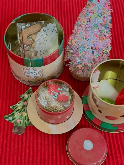 We also offer our Christmas cookies in these adorable reusable tins. This photo shows our gingerbread cookies packaged in a round tin, perfect for keeping them fresh.