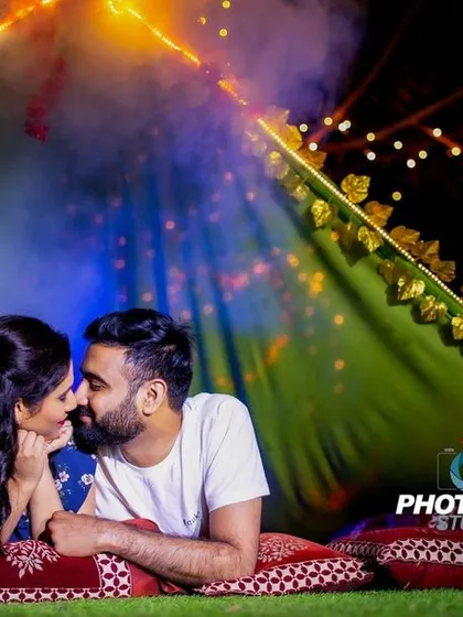 A romantic and cozy pre-wedding shoot inside a beautifully lit tent at night. The fairy lights and smoke create a dreamy, intimate atmosphere.