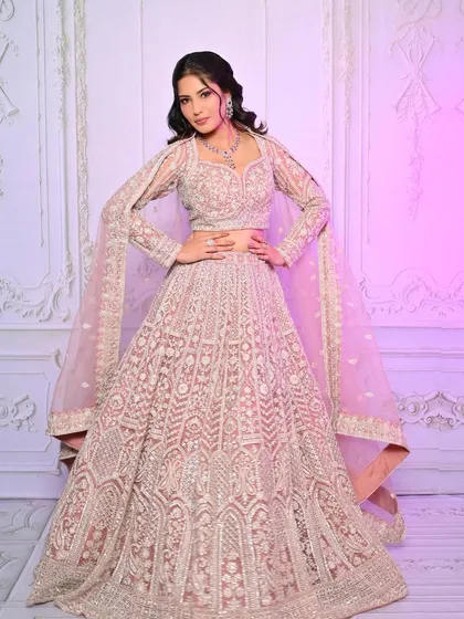 A full-length view of the pastel pink lehenga look, showing the elegant silhouette and how the makeup enhances the overall aesthetic.