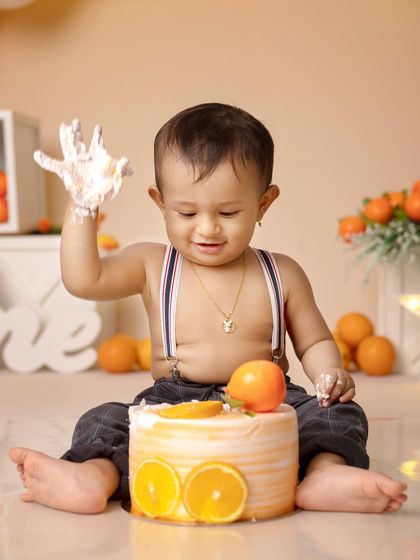 The pure joy of getting to eat cake with your hands! This little one is loving his orange-themed cake smash.