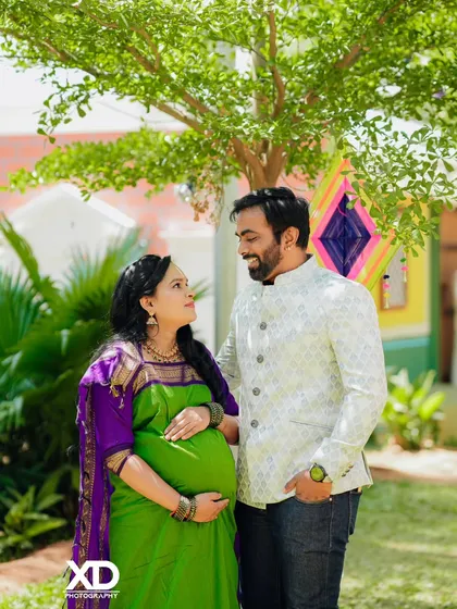 A candid moment of the couple looking at each other, sharing a smile in a garden setting.