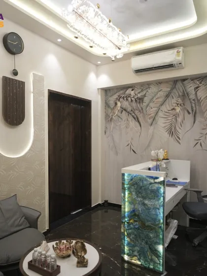 This wide shot of the reception and waiting area shows how we design a cohesive space. The consistent use of botanical wallpaper, warm lighting, and luxurious textures connects the different zones of the spa entrance.