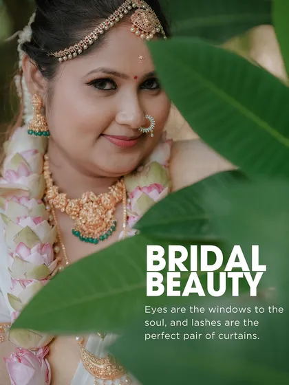 "Bridal Beauty." A creative portrait of the Kerala bride peeking through lush green leaves, drawing attention to her expressive eyes and serene smile.
