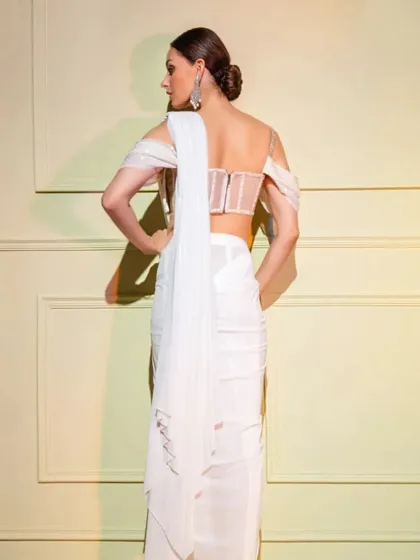 The back view of the white corset drape saree, revealing the structured boning of the corset and the delicate off-shoulder sleeves.