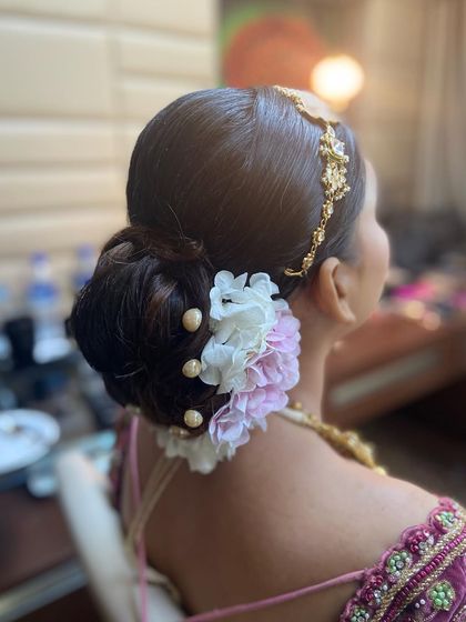 A side view showing how the floral and pearl bun is placed to complement the bride's hair jewelry.