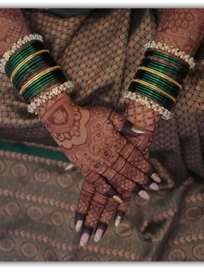 Another artistic shot of the bride's hands and bangles. The focus on the mehendi highlights the intricate patterns and the rich stain.