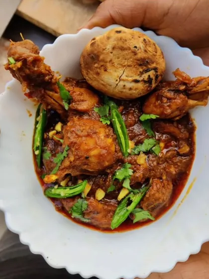 A comforting bowl of my Desi-style homemade chicken curry, prepared with a rich blend of spices and garnished with fresh green chilies. This is a popular main course option for house parties and family gatherings.