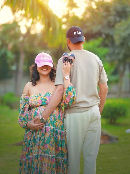 A playful and cute "Mom" and "Dad" hat pose. This is a fun way to celebrate their new roles, with the golden hour light adding a beautiful touch.