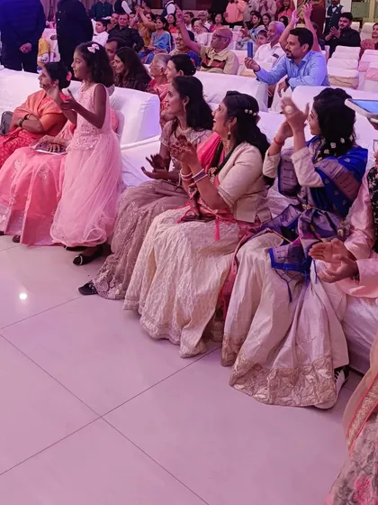 The guests, especially the younger ones, enjoying the proceedings at an engagement. Their claps and smiles add so much to the celebratory atmosphere.