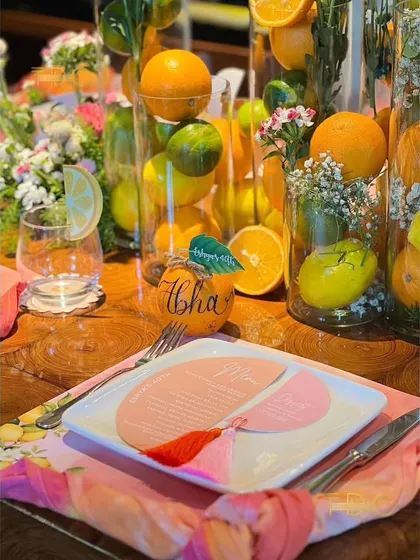 Every place setting was personalized with custom menus and name tags written on actual oranges, adding a unique and fragrant touch to the citrus-themed decor.