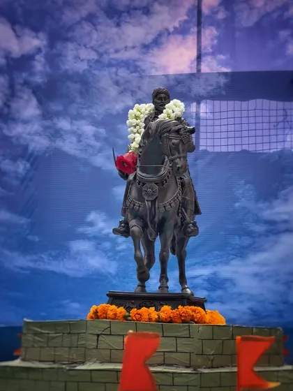 Another statue of Shivaji Maharaj, set against a dramatic blue background. This photo emphasizes the heroic and larger-than-life persona of the Maratha king.