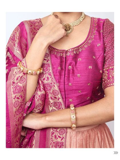 A full view of the jewellery styling for a traditional look. The temple necklace and matching bangles create a cohesive and regal effect against the rich pink fabric.