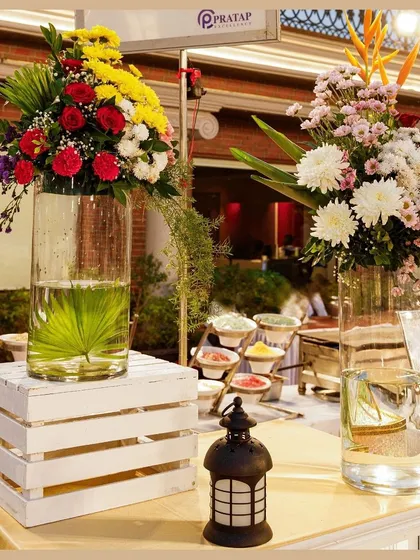 Fresh floral arrangements in tall glass vases add a touch of natural beauty and sophistication to our food stations.