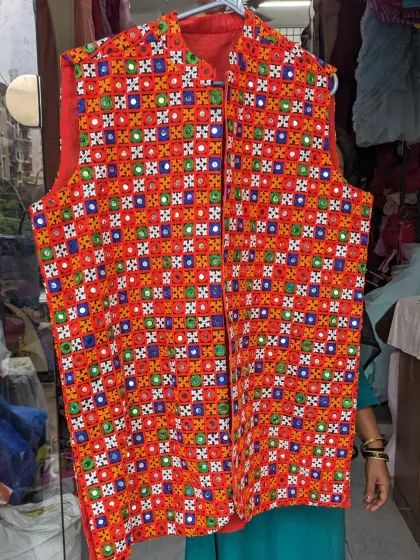 This colorful, mirror-work Navratri jacket can be worn by both men and women. You can rent or buy it to add a festive touch to your Garba outfit.