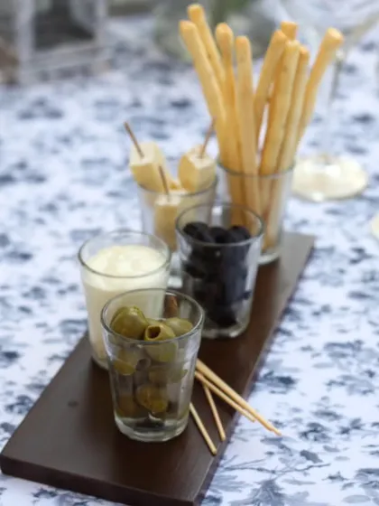 An appetizer platter with breadsticks, olives, and dips set on a beautifully patterned tablecloth. This shows our attention to detail, even in the smallest elements of the dining experience.