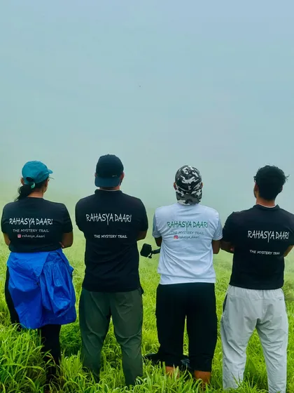 Our team members in Rahasya Daari shirts looking out at the misty green hills of the Bandaje Falls trail.