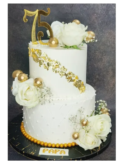 A grand 75th birthday cake for a beloved father. This two-tier fresh pineapple cake is decorated with white roses, gold leaf, and a quilted pattern for a sophisticated and celebratory look.