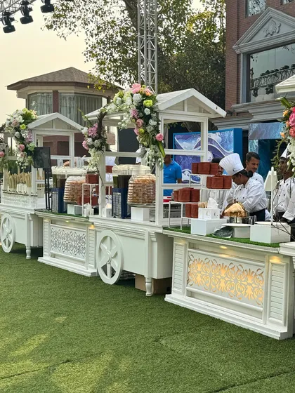 Whimsical and charming, these white food carts adorned with floral arrangements are perfect for outdoor events or themed parties. They serve as beautiful, mobile stations for snacks, desserts, or drinks.