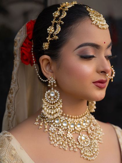 A detailed shot of the jewellery, featuring a kundan choker and long earrings, paired with a side-swept matha patti.