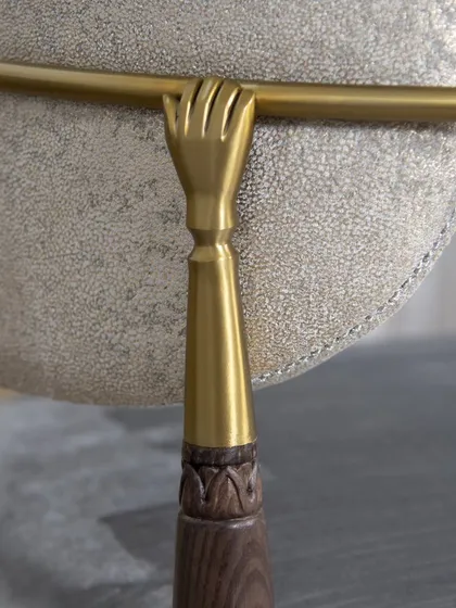 The details make the design. This close-up of our Main D’Or Chair showcases the fine craftsmanship that defines our work. The golden hand delicately grasping the backrest is a nod to an era of opulence, while the lush velvet and subtle wood carving create a rich tactile experience. It's a piece of art.