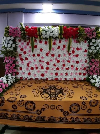 We can create a simple yet elegant floral wall as a backdrop. This design features a panel of white and red roses, framed by a border of pink and white flowers, perfect for placing behind the idol's table.