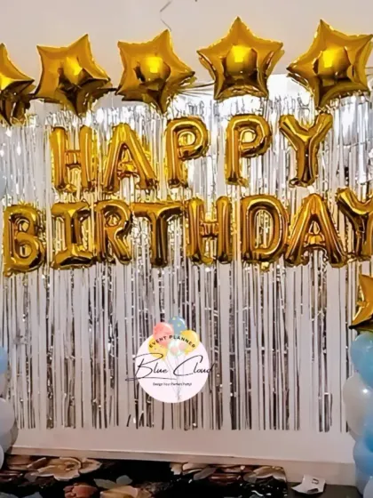 A basic birthday wall decoration with gold 'Happy Birthday' foil letters and star-shaped foils.