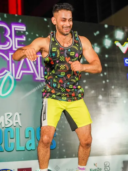 A candid shot of me smiling and dancing on stage at the 'Vibe Social 5.0' masterclass. This image captures the pure joy and fun that is at the heart of every Zumba session.