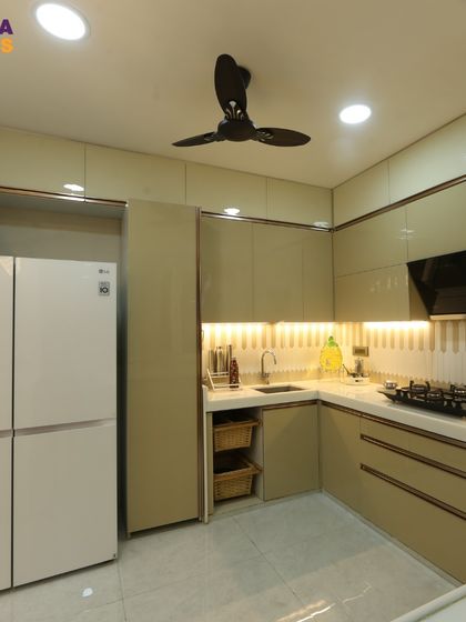 A view of the kitchen's cooking area, with a built-in hob, chimney, and plenty of storage. The under-cabinet lighting provides excellent task lighting.