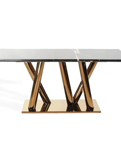 A closer look at the sculptural base of this black marble dining table. The asymmetrically balanced pedestal is finished in a high-gloss PVD gold, making it a true statement piece.