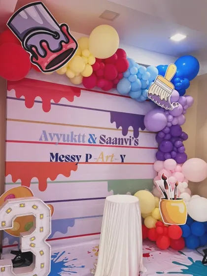 A creative and colorful 'Messy P-Art-y' theme for a 3rd birthday. The backdrop looks like a paint-splattered canvas, with fun props like paint buckets and brushes.