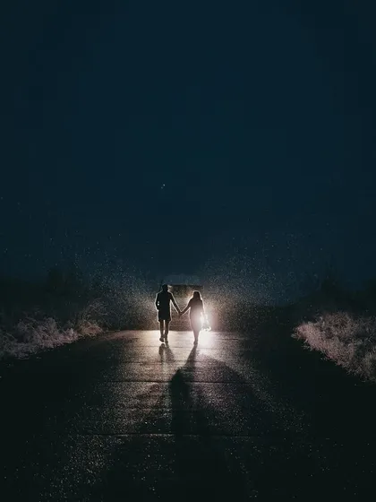 A cinematic night shot, where the couple becomes the center of their own universe. This creative pre-wedding photo uses dramatic lighting to create a sense of intimacy and adventure, proving that beautiful moments can be found long after the sun goes down.