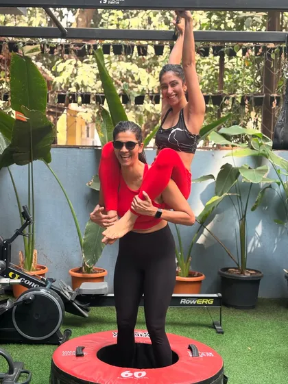 The fun and trust within our community, captured in a playful partner pose during a workout. We don't take ourselves too seriously.