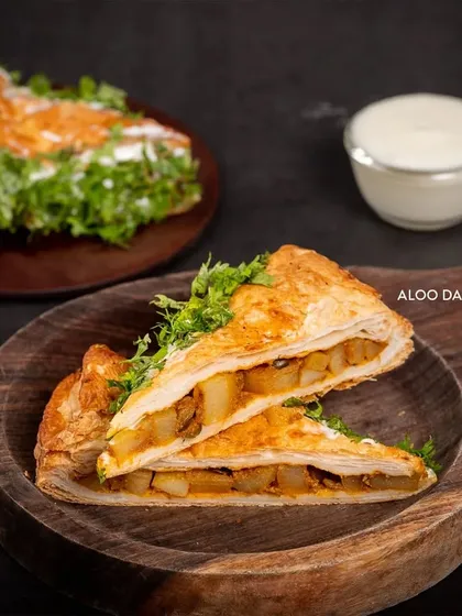 Meet the legend: our Aloo Dahi Puff. It's a unique creation with a flaky, golden crust filled with a tangy potato and yogurt mix, then topped with fresh coriander. It’s the perfect savory snack.