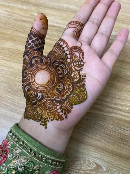 The fresh paste of a half-hand design, with a central mandala and detailed swirls.