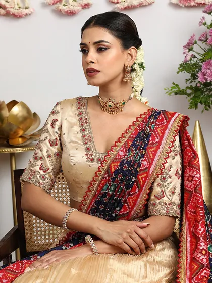 A seated portrait that captures the grace and poise of a bride in our gold and Bandhani lehenga set.