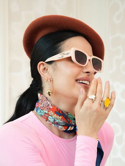 This second look for the Crocs campaign has a more eclectic, Parisian feel. I paired a simple pink bodysuit with a colorful silk scarf, a brown beret, and statement jewelry to create a playful and fashion-forward vibe.