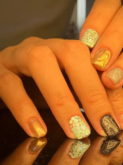 A fun and eclectic mix of short nails featuring gold chrome, black, silver glitter, and mint green with sequins.