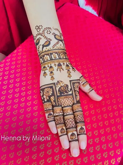 A simple yet striking design with birds, jhumkas, and an elephant, telling a little story on the back of the hand.