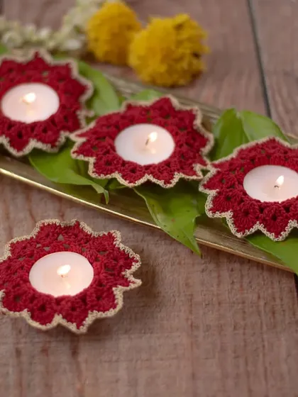 A set of our classic maroon crochet diya coasters, elegantly styled on a brass tray with fresh leaves. The gold-threaded edge adds a touch of sparkle, making them a perfect, reusable addition to your Diwali celebrations.