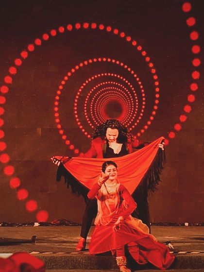 A creative pose with my Kathak partner, using a shawl against a hypnotic red spiral backdrop.