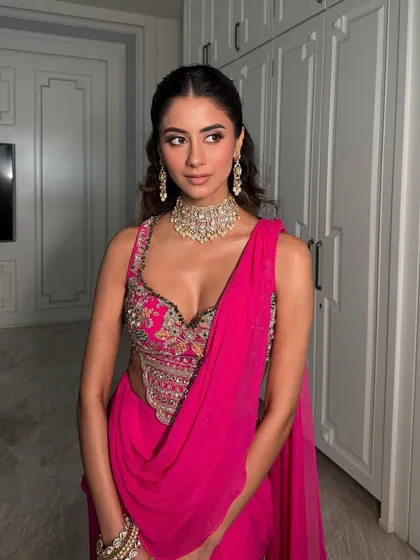 A poised and elegant shot. The half-up hairstyle and the statement necklace complete this glamorous look.